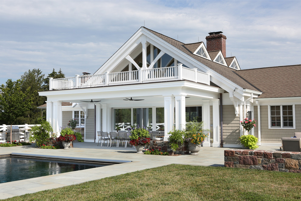 Large traditional backyard verandah in Other with natural stone pavers and a roof extension.
