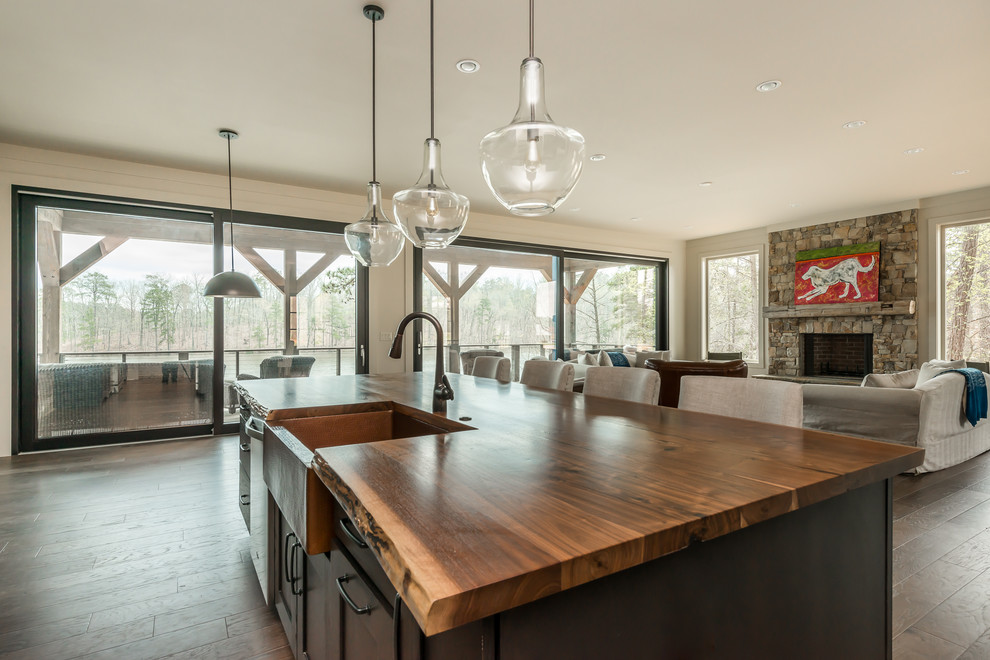 This is an example of a large country eat-in kitchen in Atlanta with a farmhouse sink, brown cabinets, wood benchtops, medium hardwood floors and with island.