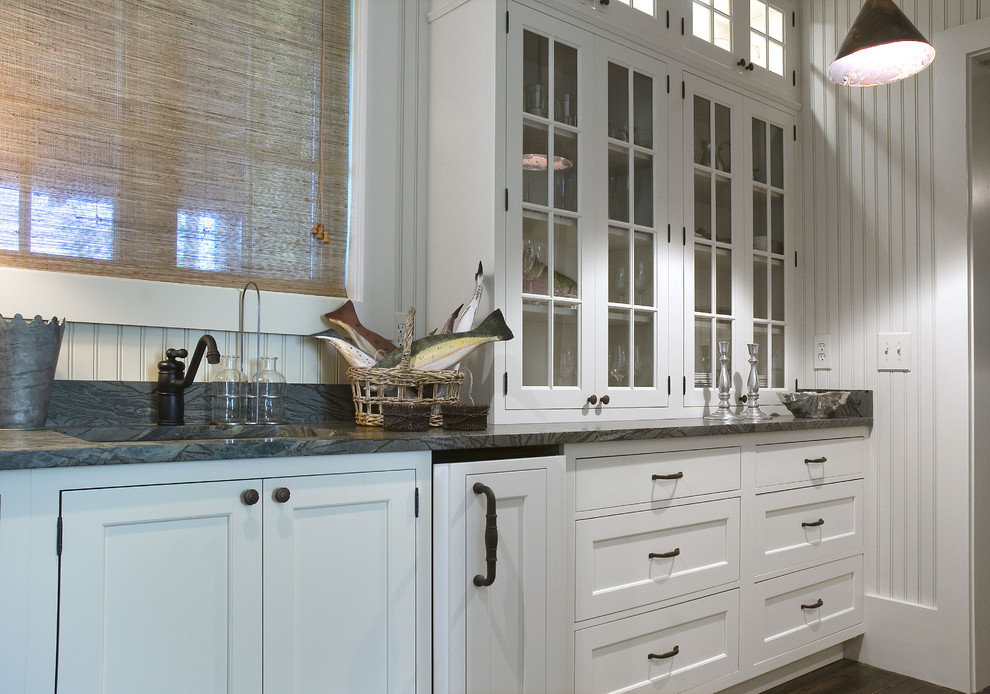 Traditional kitchen in Atlanta with glass-front cabinets, an undermount sink and white cabinets.