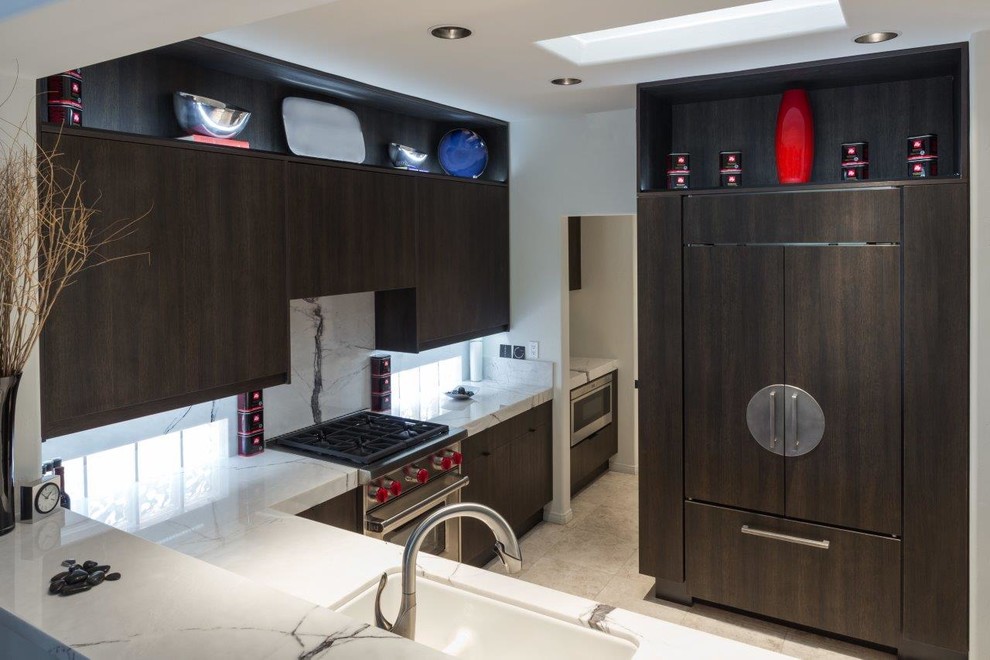 Inspiration for a mid-sized asian l-shaped separate kitchen in Phoenix with an undermount sink, flat-panel cabinets, dark wood cabinets, porcelain splashback, panelled appliances, limestone floors and no island.