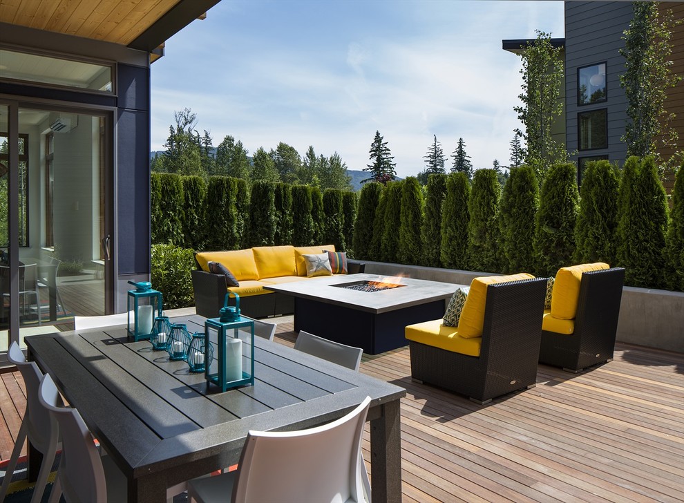 Contemporary deck in Seattle with a fire feature and a roof extension.