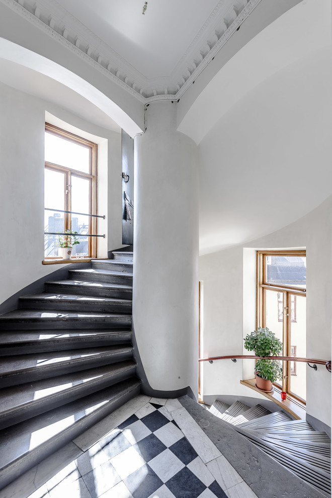 Design ideas for an expansive transitional concrete spiral staircase in Stockholm with concrete risers.