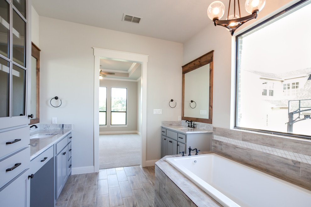 Inspiration for a large transitional master bathroom in Dallas with shaker cabinets, blue cabinets, a drop-in tub, a curbless shower, beige tile, ceramic tile, beige walls, ceramic floors, an undermount sink, granite benchtops, beige floor and a hinged shower door.
