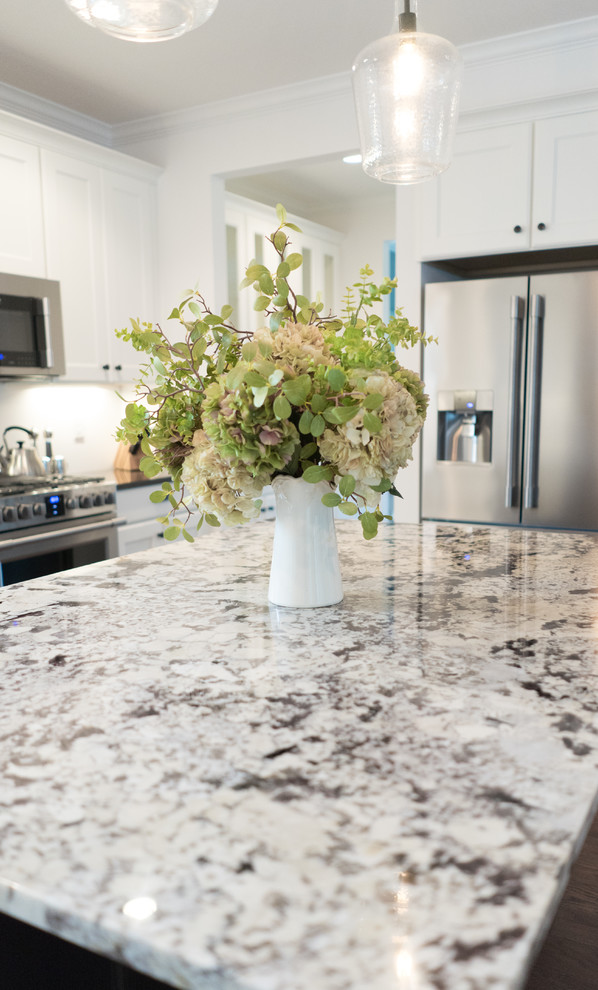 Inspiration for a mid-sized transitional l-shaped dark wood floor open concept kitchen remodel with an undermount sink, shaker cabinets, white cabinets, granite countertops, gray backsplash, stainless steel appliances and an island
