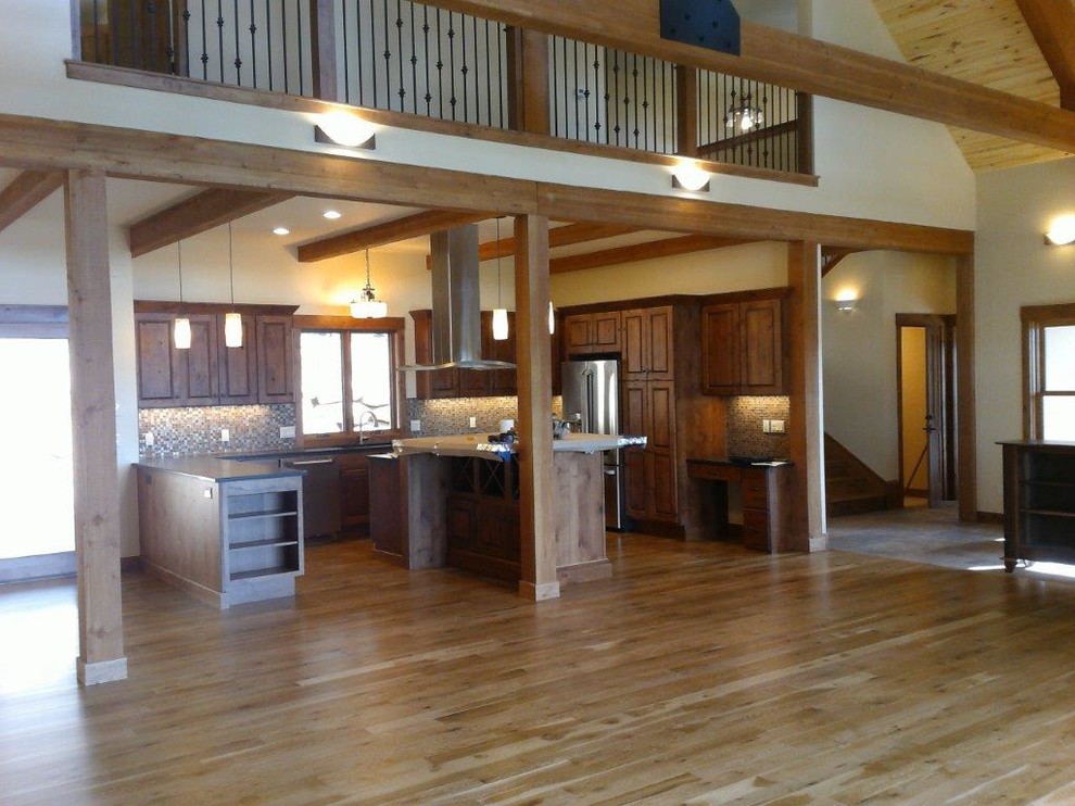 Inspiration for a large rustic u-shaped medium tone wood floor and brown floor open concept kitchen remodel with an undermount sink, raised-panel cabinets, dark wood cabinets, multicolored backsplash, glass tile backsplash, stainless steel appliances and an island