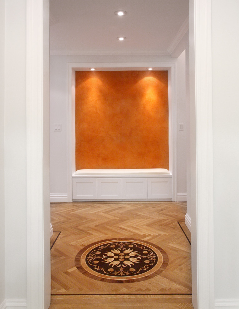 Large contemporary entry hall in New York with white walls and light hardwood floors.