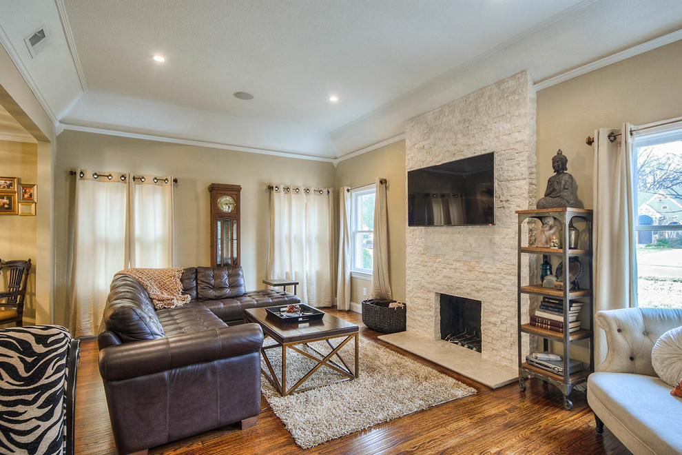 This is an example of a traditional living room in Dallas with a stone fireplace surround.
