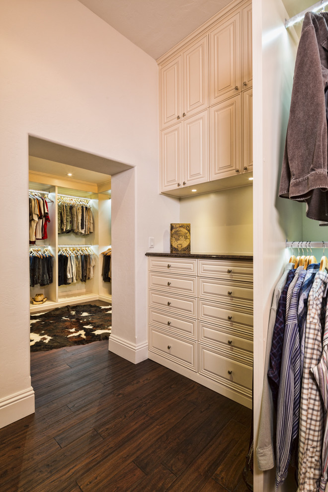 Inspiration for an expansive contemporary gender-neutral walk-in wardrobe in Tampa with raised-panel cabinets, white cabinets and vinyl floors.