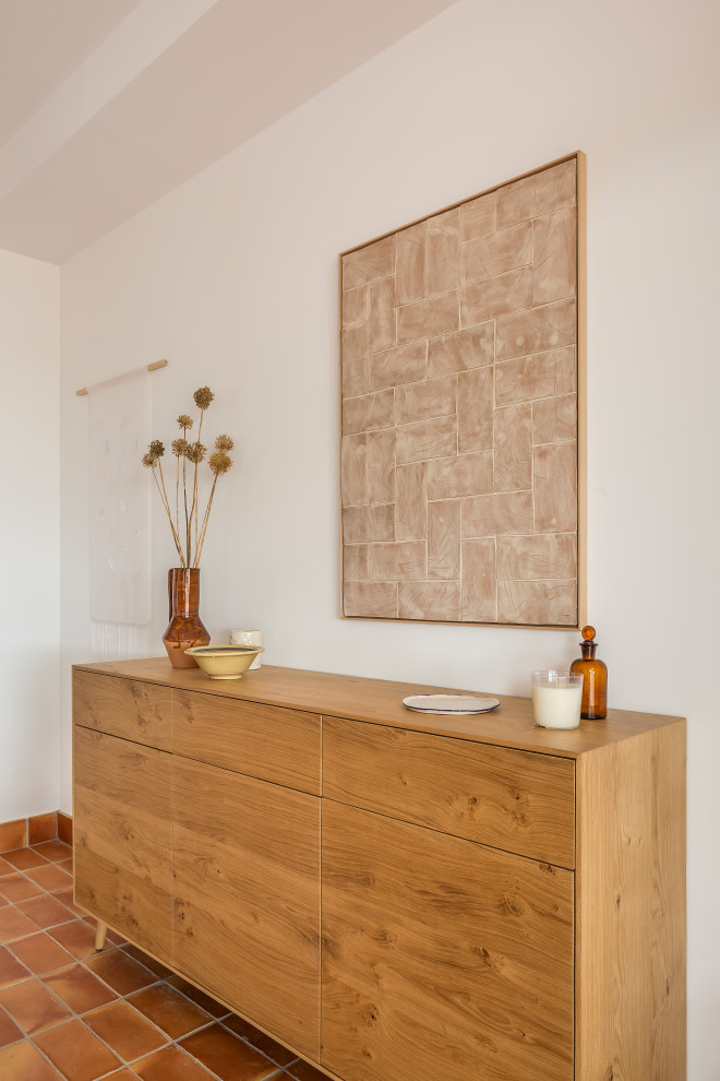 На фото: маленькая кухня-столовая в средиземноморском стиле с белыми стенами, полом из терракотовой плитки и коричневым полом для на участке и в саду с