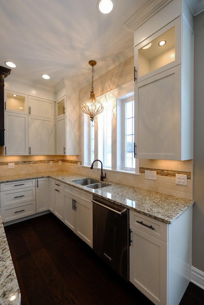 Inspiration for a large transitional u-shaped dark wood floor and brown floor eat-in kitchen remodel with an undermount sink, recessed-panel cabinets, white cabinets, granite countertops, beige backsplash, stainless steel appliances and an island
