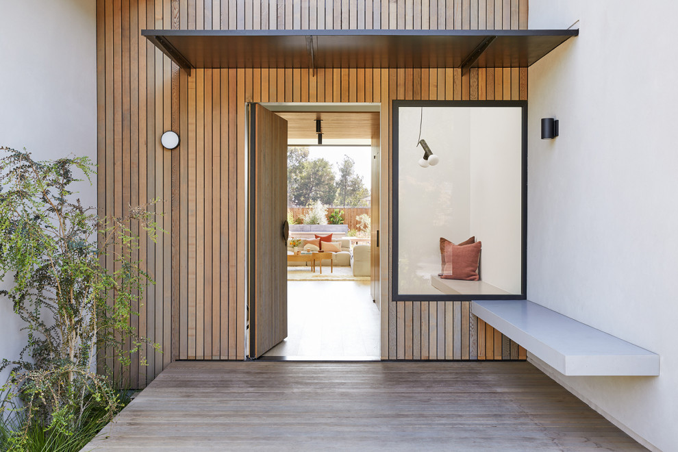 Exemple d'une grande porte d'entrée moderne en bois avec une porte pivot et une porte en bois brun.