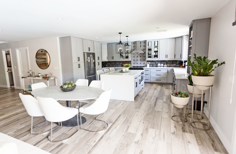 Eat-in kitchen - mid-sized transitional u-shaped light wood floor and gray floor eat-in kitchen idea in Phoenix with an undermount sink, recessed-panel cabinets, gray cabinets, quartz countertops, multicolored backsplash, ceramic backsplash, stainless steel appliances, an island and white countertops