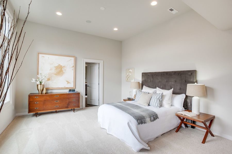 Expansive contemporary master bedroom in Seattle with carpet.