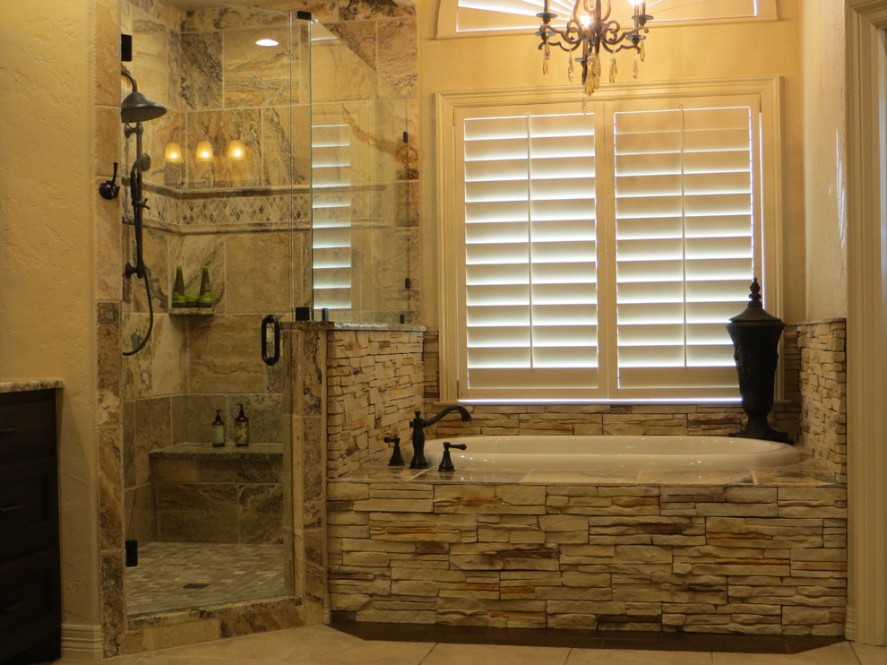 Inspiration for a large country master bathroom in Dallas with an undermount sink, dark wood cabinets, granite benchtops, a drop-in tub, a corner shower, a two-piece toilet, brown tile, stone tile, beige walls and ceramic floors.