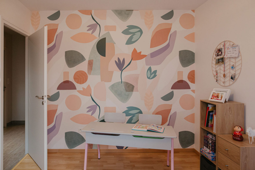 This is an example of a mid-sized country kids' bedroom for kids 4-10 years old and girls in Other with pink walls, laminate floors and wallpaper.
