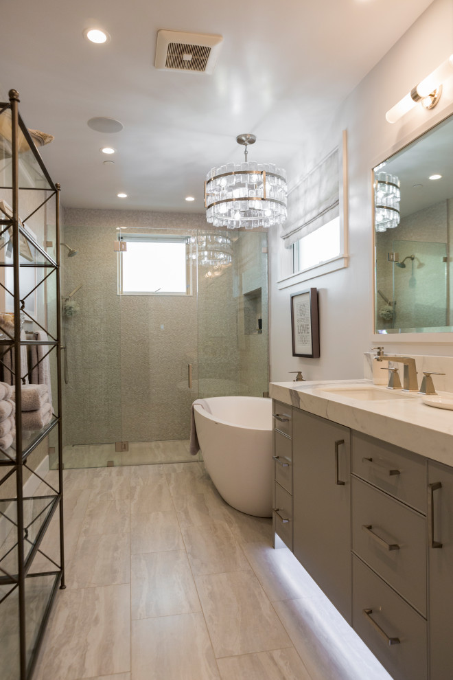 Photo of a medium sized nautical ensuite bathroom in Los Angeles with beaded cabinets, grey cabinets, a freestanding bath, a built-in shower, a two-piece toilet, grey walls, porcelain flooring, a submerged sink, engineered stone worktops, beige floors, a hinged door, white worktops, a shower bench, double sinks, a built in vanity unit and wallpapered walls.