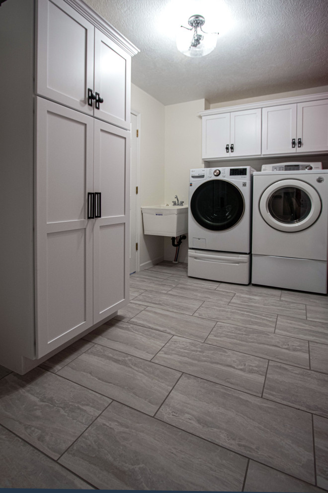 Small transitional dedicated laundry room in Cleveland with an utility sink, flat-panel cabinets, white cabinets, ceramic floors, a side-by-side washer and dryer and grey floor.