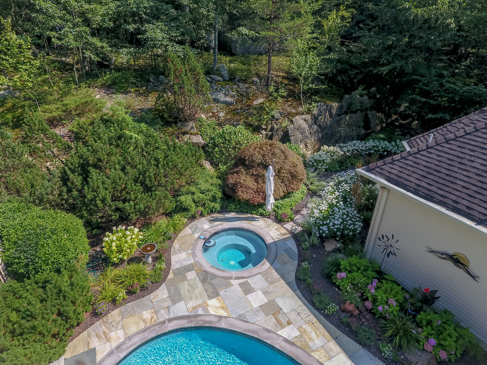 Large traditional backyard kidney-shaped lap pool in New York with a hot tub and tile.