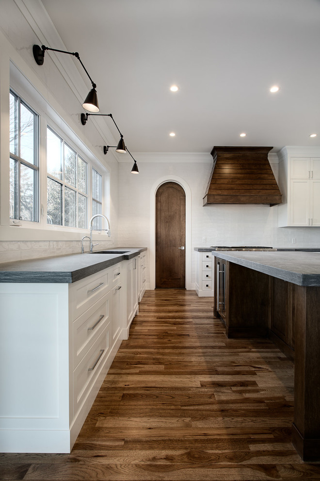 Large transitional u-shaped eat-in kitchen photo in Calgary with shaker cabinets, paneled appliances and an island