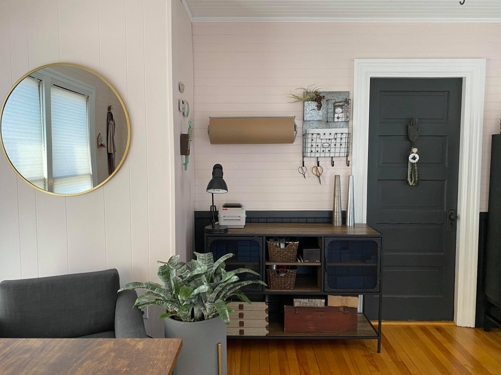 Small industrial home studio in Portland Maine with pink walls, medium hardwood floors, a freestanding desk, wood and wood walls.