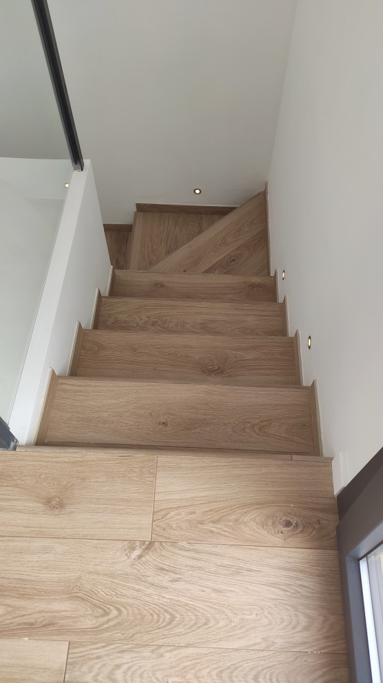 This is an example of a medium sized modern tiled u-shaped staircase in Other with tiled risers.
