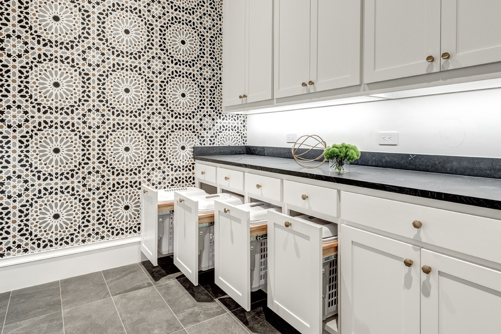 Inspiration for a large mediterranean galley dedicated laundry room in Dallas with an undermount sink, shaker cabinets, white cabinets, granite benchtops, white walls, a side-by-side washer and dryer, black benchtop, porcelain floors and grey floor.