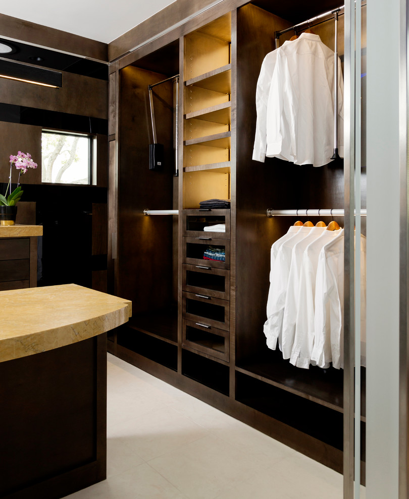 Large transitional gender-neutral walk-in wardrobe in Houston with flat-panel cabinets, dark wood cabinets and porcelain floors.