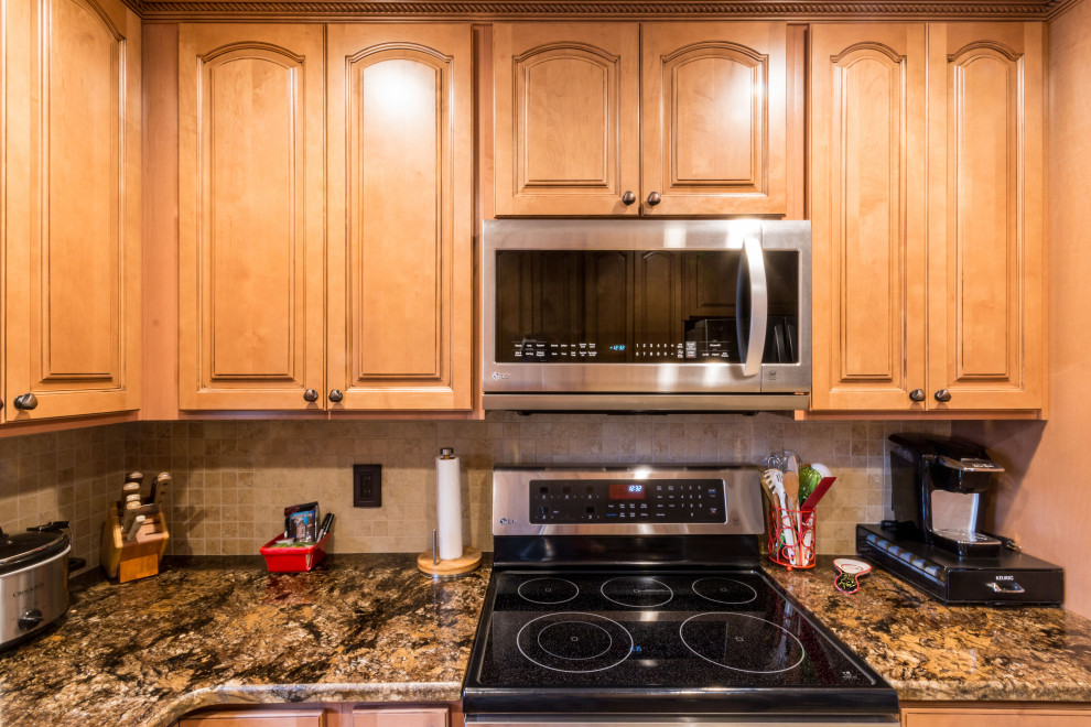 Eat-in kitchen - mid-sized u-shaped cement tile floor and beige floor eat-in kitchen idea with an undermount sink, raised-panel cabinets, medium tone wood cabinets, granite countertops, stainless steel appliances, no island and brown countertops