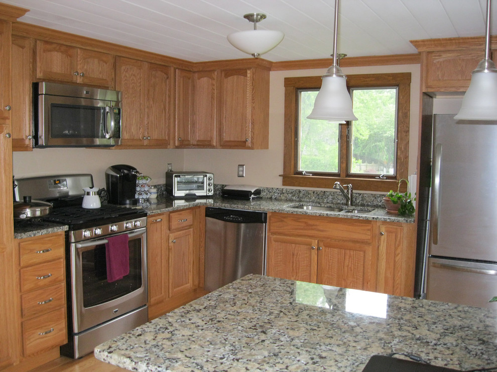 Inspiration for a mid-sized transitional l-shaped light wood floor kitchen remodel in Boston with light wood cabinets, flat-panel cabinets, granite countertops, a peninsula, stainless steel appliances and an undermount sink