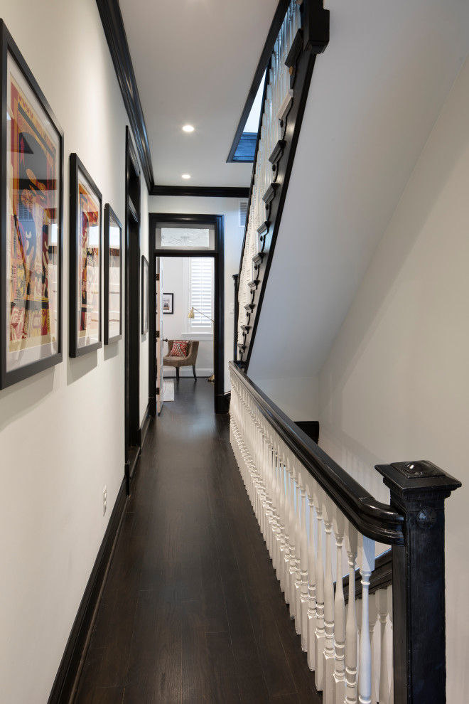 Foto de recibidores y pasillos bohemios de tamaño medio con paredes blancas, suelo de madera oscura y suelo negro