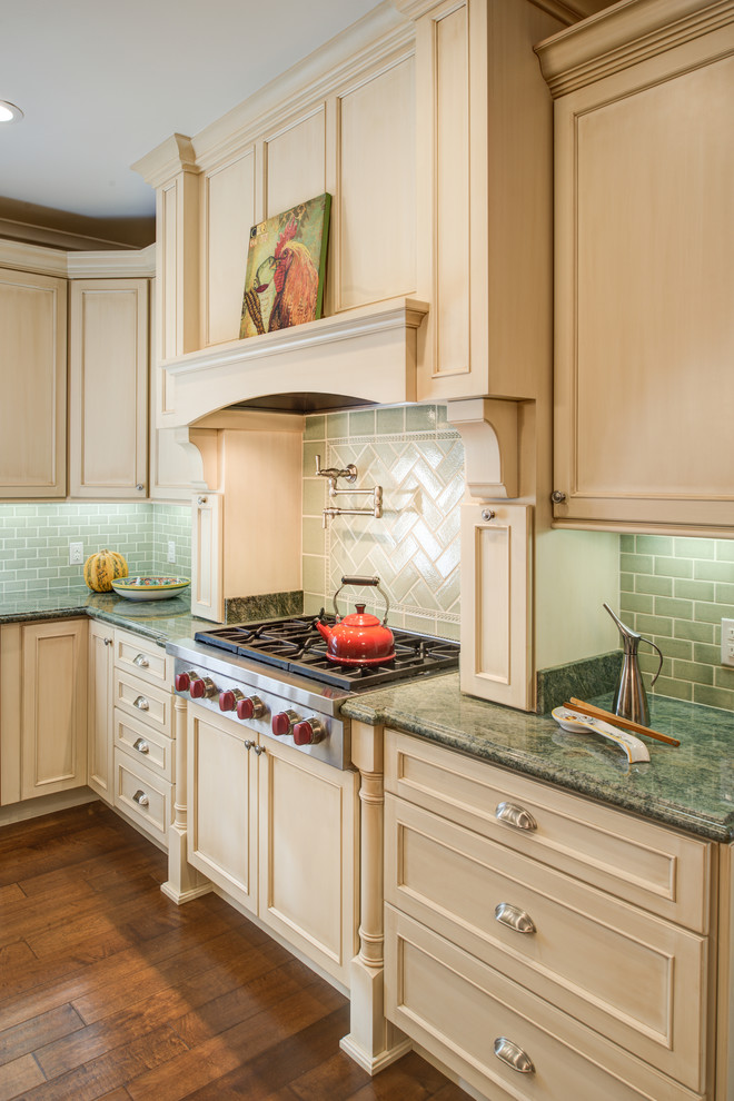 Mid-sized traditional l-shaped eat-in kitchen in San Francisco with an undermount sink, recessed-panel cabinets, beige cabinets, granite benchtops, green splashback, glass tile splashback, stainless steel appliances, medium hardwood floors and with island.