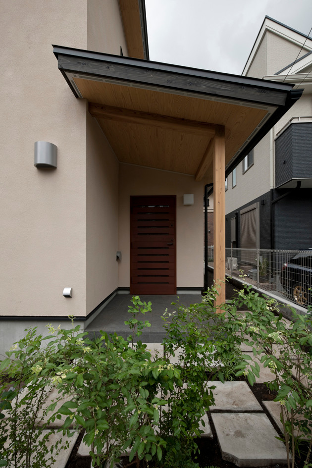 Design ideas for a mid-sized scandinavian front door in Tokyo Suburbs with beige walls, porcelain floors, a single front door, a brown front door, black floor, wood and panelled walls.