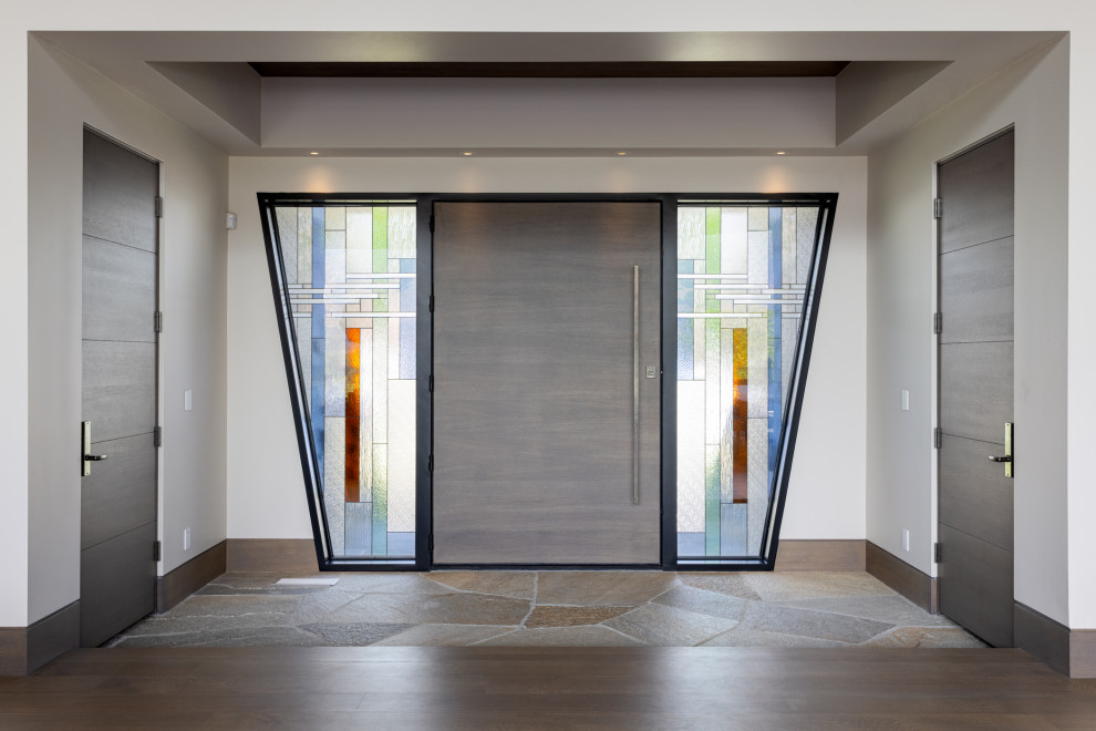 ソルトレイクシティにあるラグジュアリーな巨大なアジアンスタイルのおしゃれな玄関ドア (ベージュの壁、トラバーチンの床、木目調のドア、茶色い床、格子天井) の写真