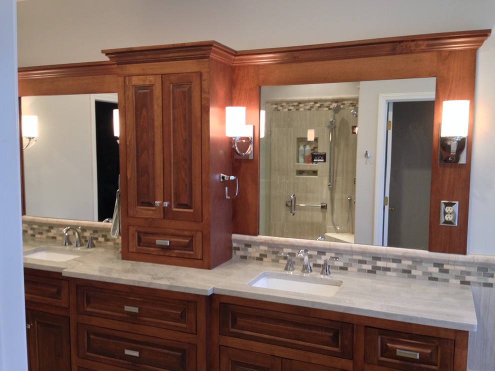 Drop-in bathtub - mid-sized transitional master gray tile, multicolored tile and stone tile porcelain tile drop-in bathtub idea with raised-panel cabinets, dark wood cabinets, an undermount sink and marble countertops