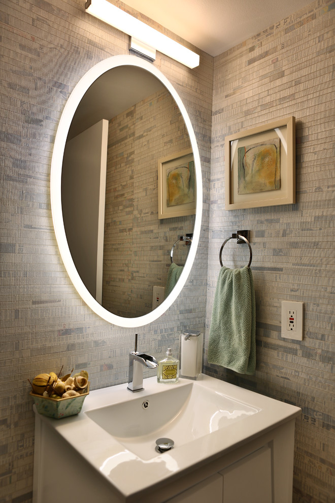 Photo of a mid-sized contemporary powder room in Miami with flat-panel cabinets, white cabinets, an integrated sink, solid surface benchtops, beige tile and beige walls.