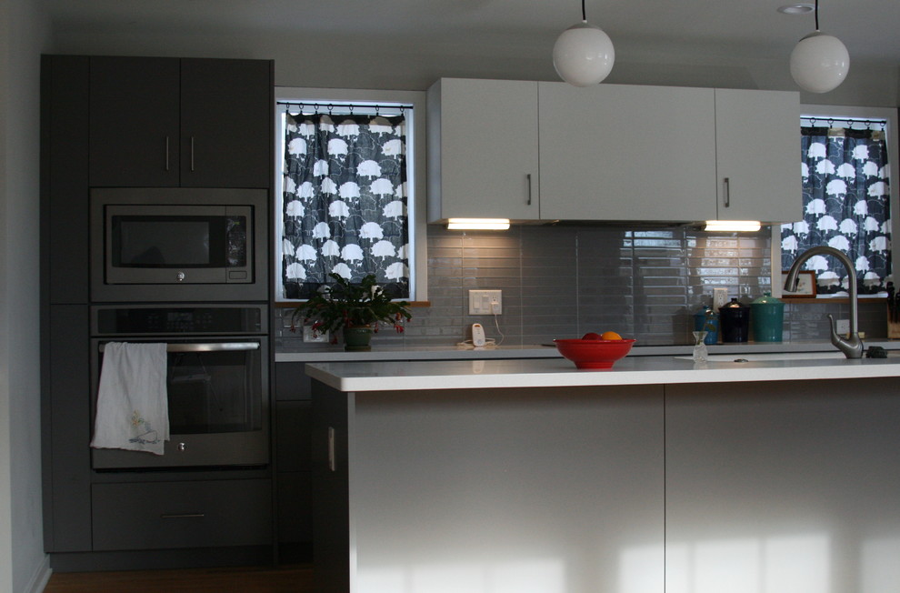 This is an example of a mid-sized modern single-wall kitchen in Minneapolis with flat-panel cabinets and with island.