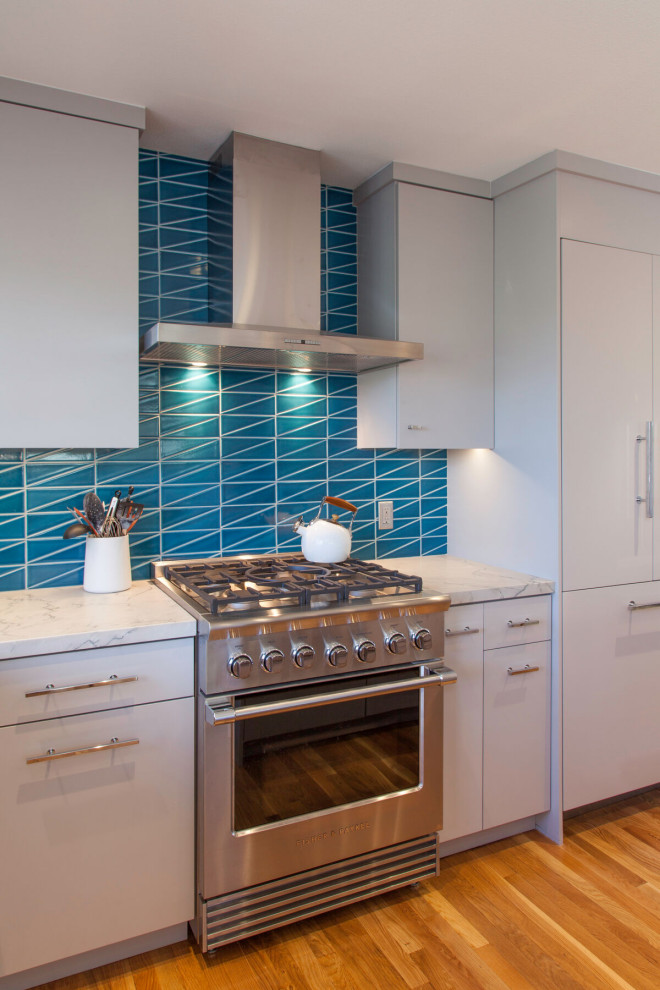 Idée de décoration pour une cuisine design avec une crédence bleue et une crédence en céramique.
