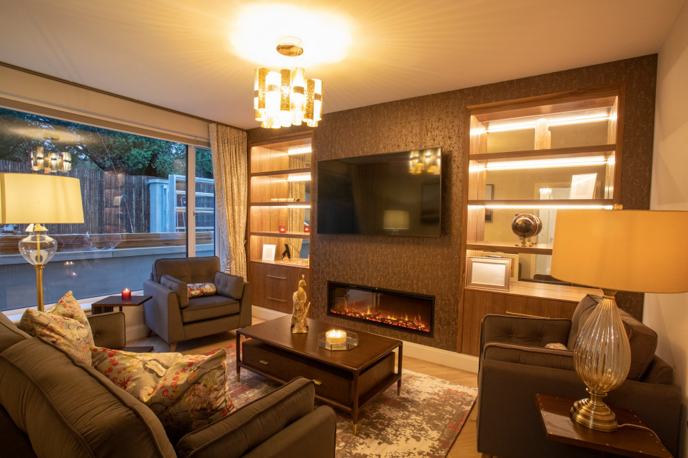 Immagine di un soggiorno minimalista con pareti marroni, pavimento in laminato, TV a parete e carta da parati