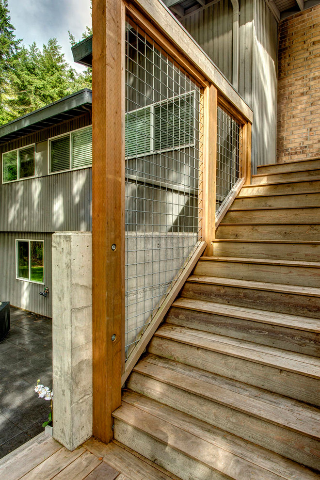 Example of a minimalist backyard deck design in Seattle with a roof extension