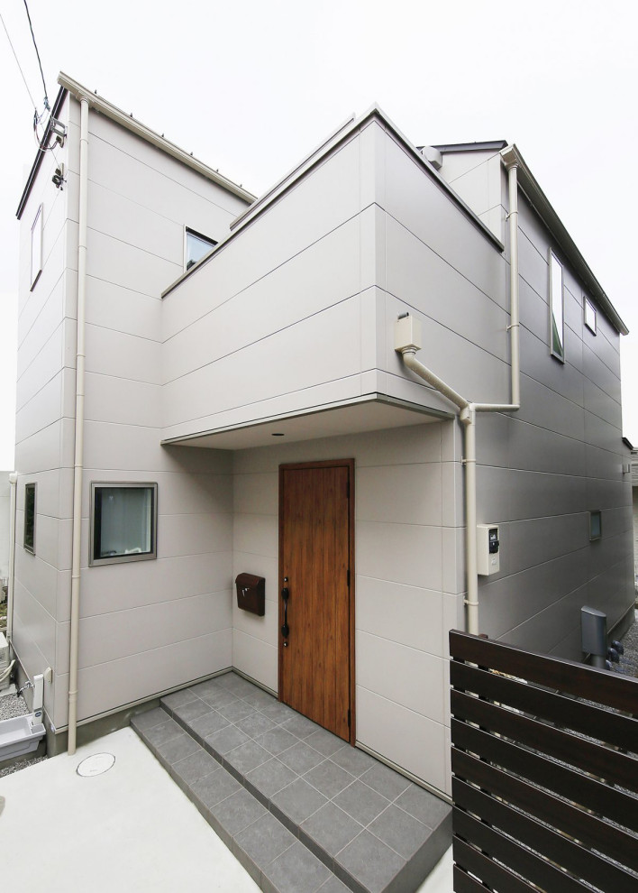 Kleines, Zweistöckiges Industrial Einfamilienhaus mit Mix-Fassade, weißer Fassadenfarbe, Halbwalmdach, Blechdach und schwarzem Dach in Tokio Peripherie