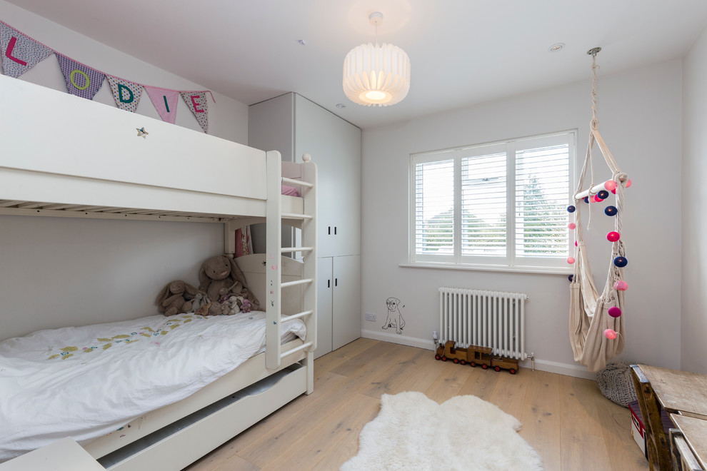 Contemporary gender-neutral kids' study room in London with multi-coloured walls and light hardwood floors.