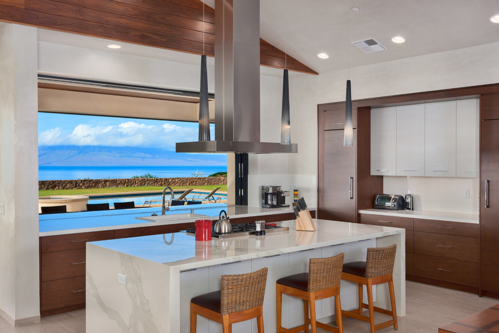 This is an example of a large contemporary l-shaped separate kitchen in Hawaii with flat-panel cabinets, medium wood cabinets, with island, a drop-in sink, window splashback, beige floor, porcelain floors, quartz benchtops, white splashback and panelled appliances.
