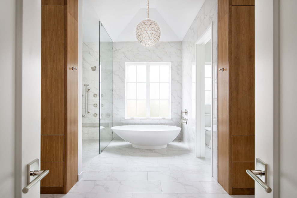 This is an example of a mid-sized contemporary master bathroom in Austin with flat-panel cabinets, white cabinets, a curbless shower, a two-piece toilet, white tile, porcelain tile, white walls, ceramic floors, an undermount sink, solid surface benchtops, white floor, a hinged shower door, white benchtops, a shower seat, a built-in vanity, timber, planked wall panelling and a double vanity.