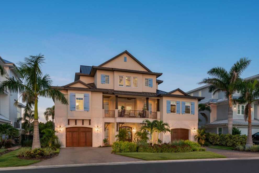Large tropical three-storey stucco white house exterior in Tampa with a hip roof and a metal roof.