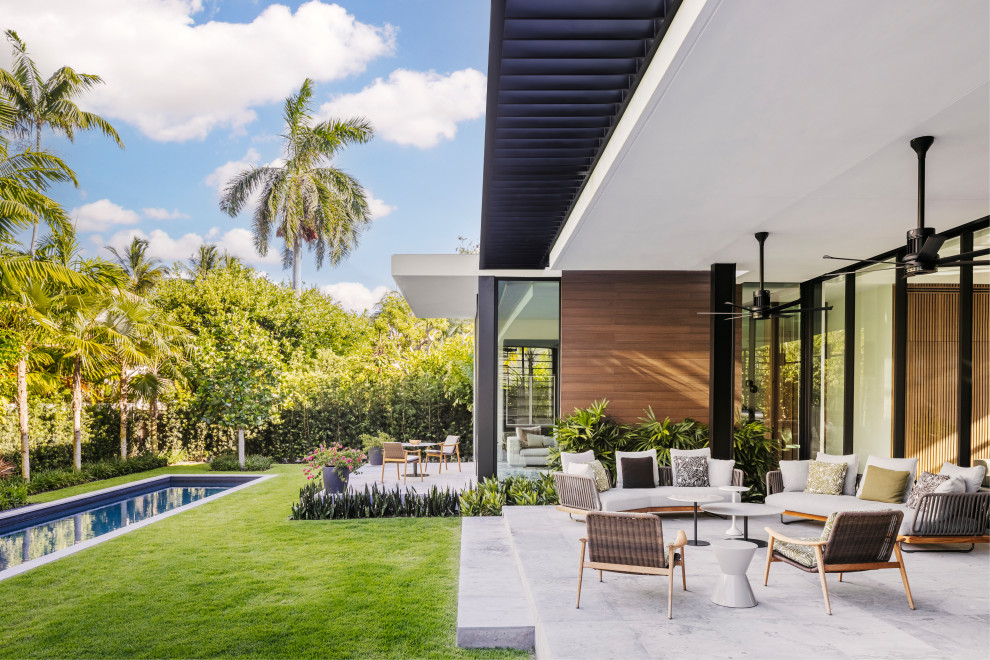 Свежая идея для дизайна: двор на заднем дворе в стиле модернизм с покрытием из бетонных плит и навесом - отличное фото интерьера