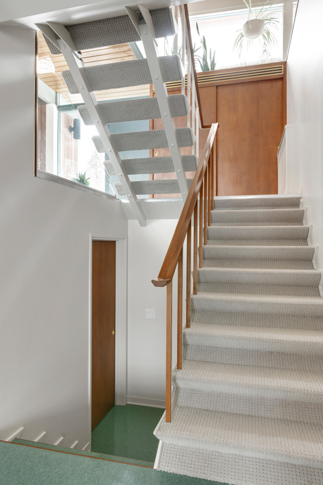 Imagen de escalera suspendida retro de tamaño medio con escalones enmoquetados y barandilla de madera