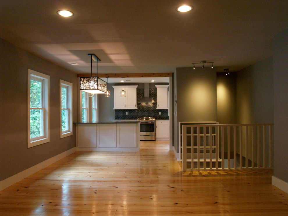 Photo of a mid-sized arts and crafts open concept living room in Atlanta with grey walls, light hardwood floors, a two-sided fireplace, a tile fireplace surround and no tv.