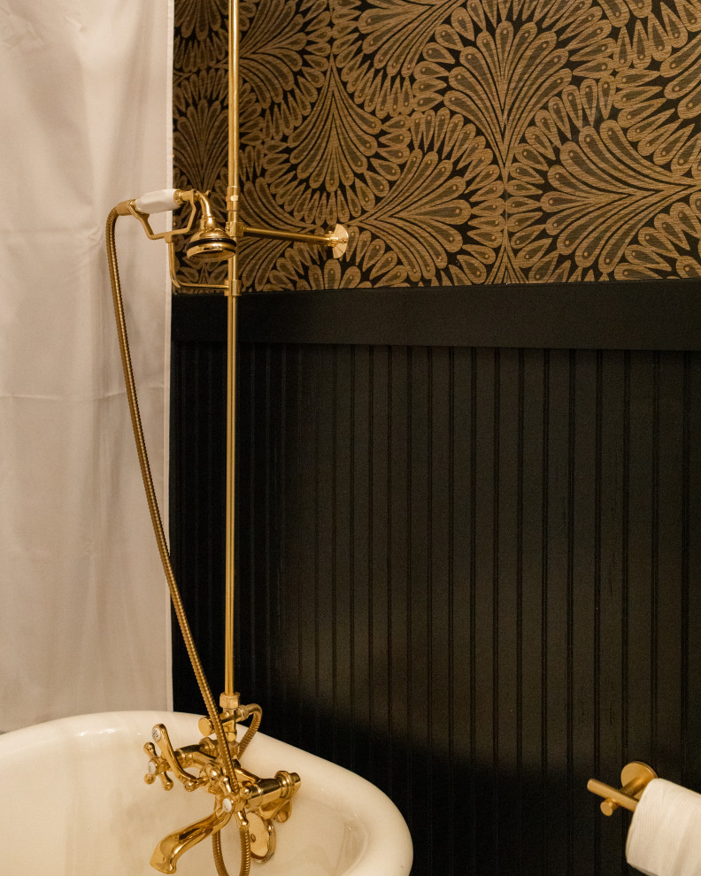 This is an example of a small victorian ensuite bathroom in Dallas with a claw-foot bath, a shower/bath combination, black walls, black floors, a single sink, a floating vanity unit and wallpapered walls.