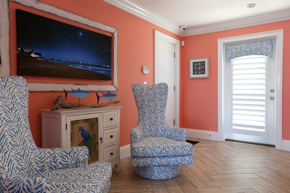 This is an example of a mid-sized beach style vestibule in Orlando with orange walls, porcelain floors, a double front door, a white front door and beige floor.