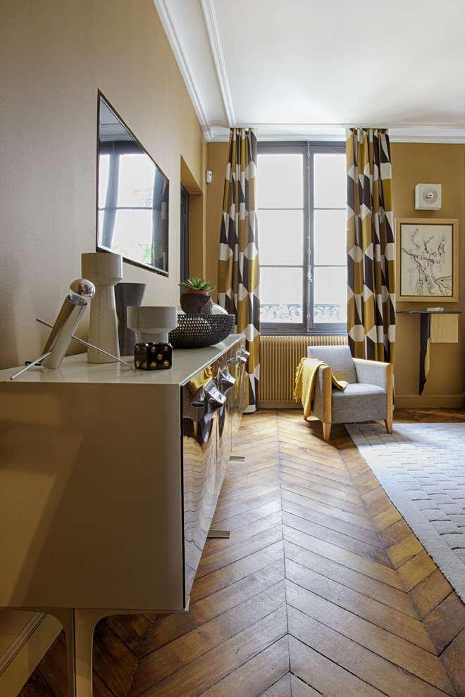 This is an example of a mid-sized eclectic master bedroom in Paris with yellow walls and light hardwood floors.